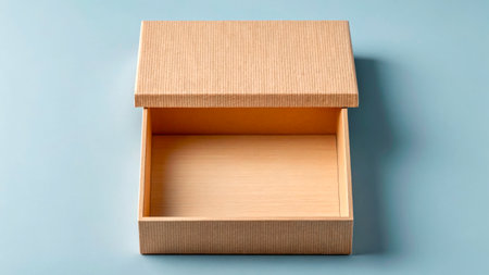 A wooden box with a smooth finish and a textured lid sits open on a light blue surface. The interior is empty, showing its simple design and natural color.の素材