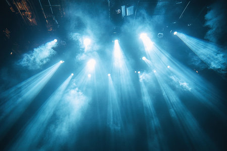 Bright spotlights shine through smoky atmosphere on a concert stage, creating a dramatic and captivating visual effect. Ideal for themes related to live performances and entertainment.の素材