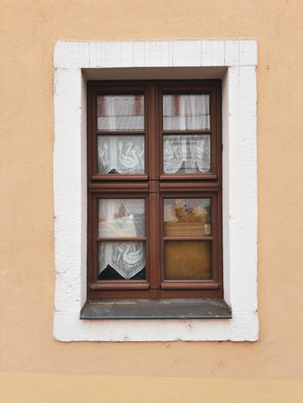 Vintage window with wooden frame and thick glass. Exterior. Old architecture.