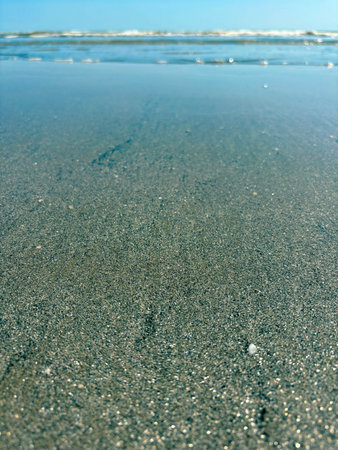 Sparkling sand on a shallow in the Ligurian Sea. Panorama of the seashore with a close-up of the...