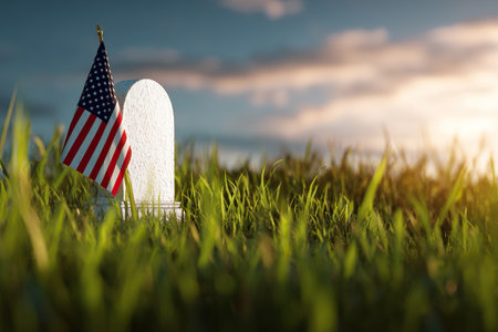 A small US flag on the green grass near a grave. A symbol of American courage and sacrifice. Remembrance Day, Veterans Day, and other patriotic holidays in the US.の素材