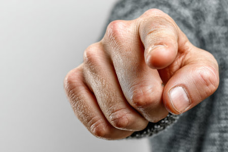 A man's hand, pointing his index finger directly at the camera, against a white background. His right hand demonstrates the gesture in close-up. The finger is pointing at you.の素材