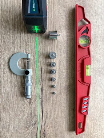 Measuring instruments are laid out on a wooden table. Laser and bubble level. Micrometerの写真素材
