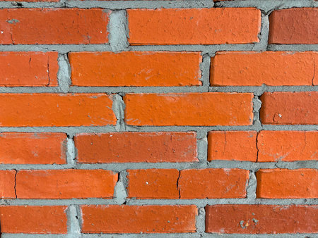Close-up of a wall made of red brick laid with cement mortar. Red brick wall texture backgroundの写真素材