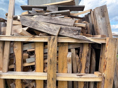 A pile of used broken lumber is stacked at a construction site. Collection of construction waste.の写真素材