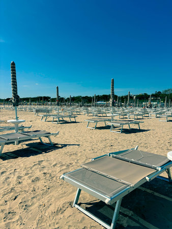The beginning of the beach season, empty sun loungers on the white sandy beach