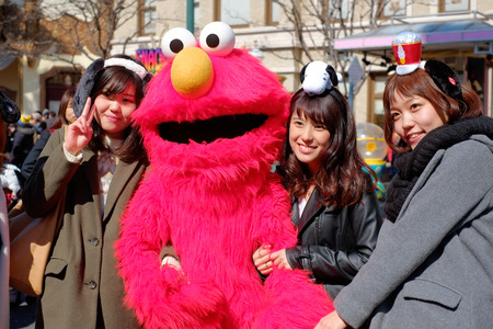 Happy asian girls take shot with Sesame Street Elmo in Universal Studios Japan (USJ), Osaka, Japanのeditorial素材