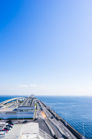 panoramic bird eye top aerial view with beautiful sea level with highway road under dramatic clear glow and fantasy blue sky in Umi Hotaru parking area island Tokyo bay aqua line, Japanのeditorial素材