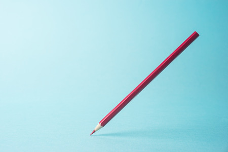 Business concept - one red color pencil stand on blue paper background. It's symbol of key point and confident.の写真素材