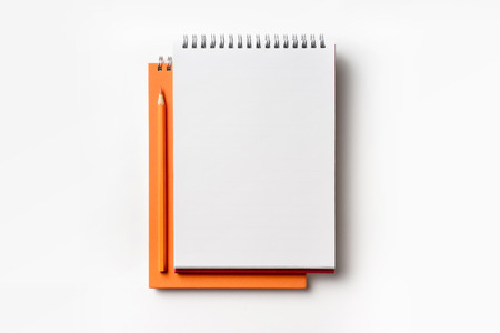 Design concept - Top view of orange spiral notebook and color pencil collection isolated on white background for mockupの写真素材