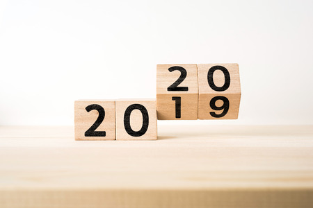 Business and design concept - surreal abstract geometric floating wooden cube with word " 2020 & 2019 " concept on wood floor and white backgroundの写真素材