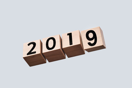 Business and design concept - surreal abstract geometric floating wooden cube with word 2019 and...