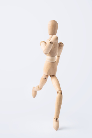 Business and design concept - running wooden mannequin isolated on white backgroundの写真素材