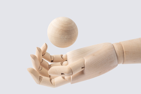 Business and design concept - wooden hand with wood ball isolated on white backgroundの写真素材