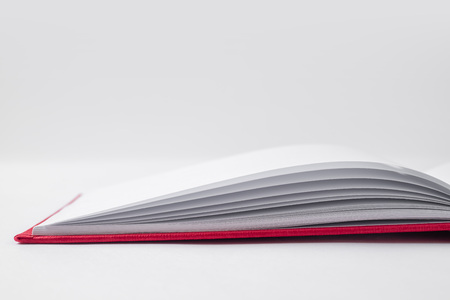 Design concept - Perspective view red hardcover notebook with open and flip curl rolled page isolated on background for mockup.の写真素材