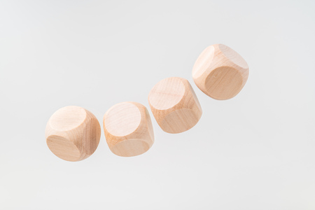 Business and design concept - Abstract geometric real floating wooden dice isolated on backgroundの写真素材