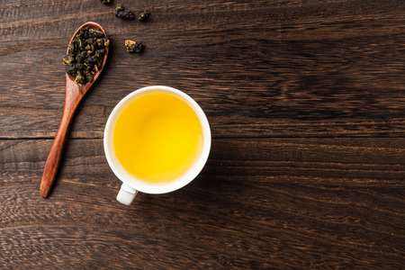 Asia culture and design concept - fresh taiwan oolong tea and cup on dark wood backgroundの写真素材