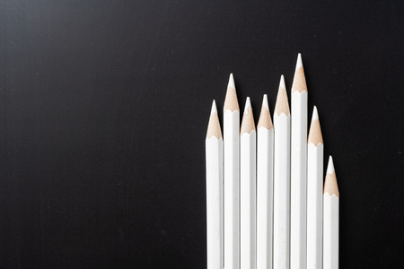 Business and design concept - lot of white pencils and one color pencil on black background. It's symbol of leadership, teamwork, success and unique.の写真素材