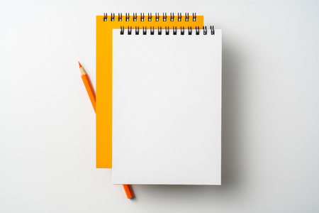 Design concept - Top view of two spiral orange notebook and pen isolated on white background for mockupの写真素材