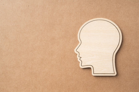 Business and design concept - wooden man head silhouette icon on kraft paper