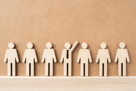 Business and design concept - group of wooden businessman icon raise hand on kraft paper. it's...