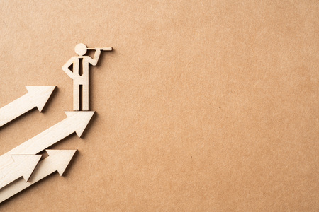 Business and design concept - group of wooden businessman icon with telescope on kraft paper. it's conversation, leadership and teamwork conceptの写真素材