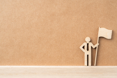 Business and design concept - group of wooden businessman icon with flag on kraft paper. it's conversation, leadership and teamwork conceptの写真素材