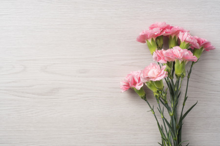 Design concept - top view of bunch of beautiful carnation on white vintage wooden background for mother day mockupの写真素材