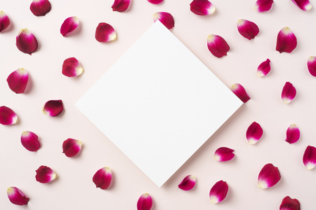 Design concept - top view of red rose petal pattern with white blank square card on pink background for mother, wedding and valentine day mockupの写真素材
