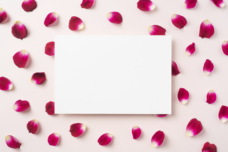 Design concept - top view of red rose petal pattern with white blank card on pink background for mother, wedding and valentine day mockupの写真素材