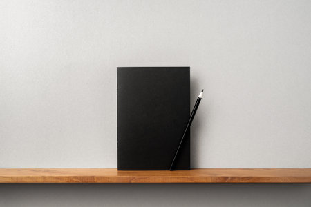 Design concept - front view of black magazine stand on bookshelf and grey wall for mockup