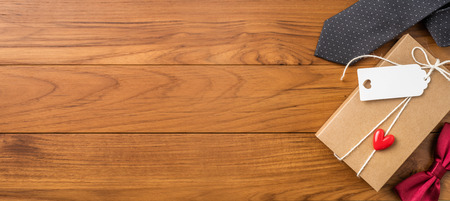 event design concept - top view of fathers day layout with kraft gift box, silhouette of eye glasses and beard, butterfly bow tie, copy space for mock upの写真素材