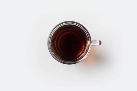 Top view of glass cup of hot tea on white background desk for mockupの写真素材