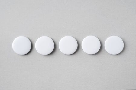 Design concept - top view of 5 white badge on grey background for mockup, it's real photo, not 3D renderの写真素材