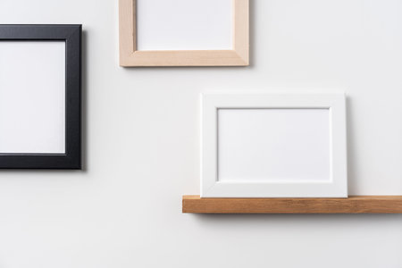 Design concept - front view of horizontal black and white wood photo frame on bookshelf and white...