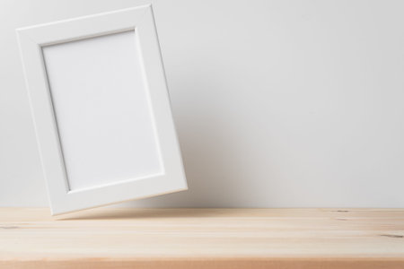 Design concept - front view of vertical white wood photo frame on wood floor and mid air with white...
