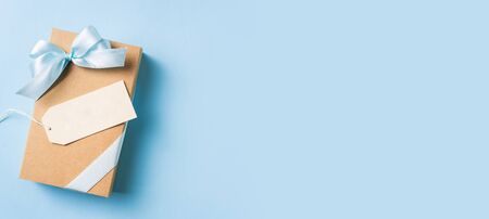 event design concept - top view of fathers day layout with ribbon kraft gift box, white label on blue background, copy space for mock upの写真素材