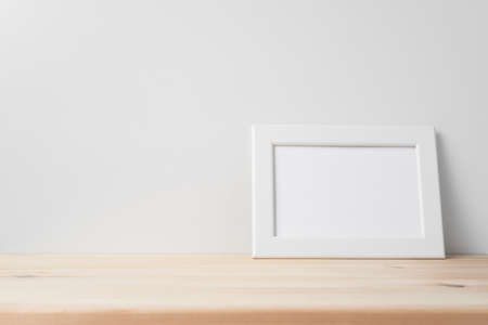 Design concept - front view of horizontal white wood photo frame on wood floor whit white wall for mockupの写真素材