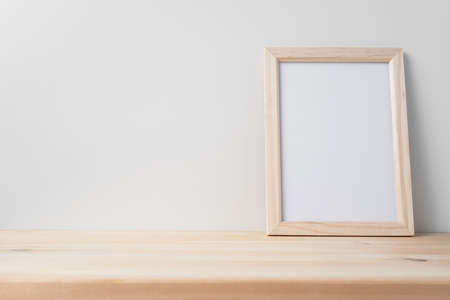 Design concept - front view of vertical wood photo frame on wood floor whit white wall for mockupの写真素材