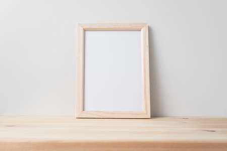 Design concept - front view of vertical wood photo frame on wood floor whit white wall for mockupの写真素材