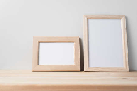 Design concept - front view of wood photo frame on wood floor whit white wall for mockupの写真素材
