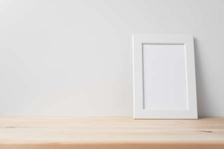 Design concept - front view of vertical white wood photo frame on wood floor whit white wall for mockupの写真素材