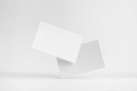 Design concept - front view of 2 surreal white business card float on mid air isolated on white background for mockup, it's real photo, not 3D renderの写真素材