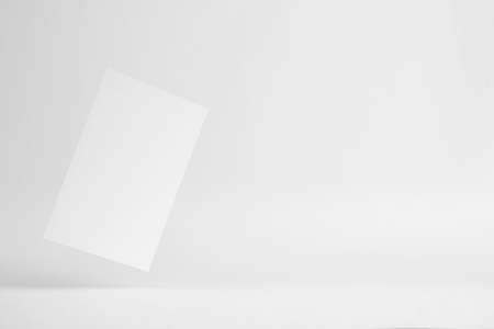 Design concept - front view of surreal white business card float on mid air isolated on white background for mockup, it's real photo, not 3D renderの写真素材