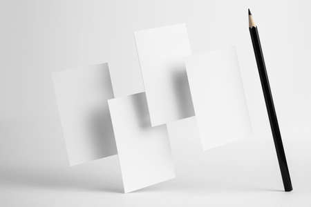 Design concept - front view of 4 surreal white business and black pencil card float on mid air isolated on white background for mockup, it's real photo, not 3D renderの写真素材