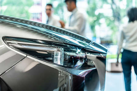 front view of new modern silver car led headlight in showroomの写真素材