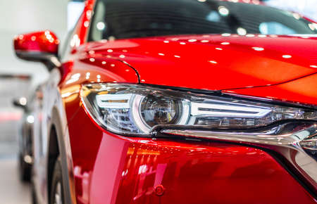 front view of new modern red car led headlight in showroomの写真素材