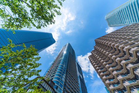 Asia Business concept for real estate, corporate construction and ecology - looking up view of panoramic modern city skyline with blue sky and green tree in Azabudai Hills, tokyo, japanの写真素材