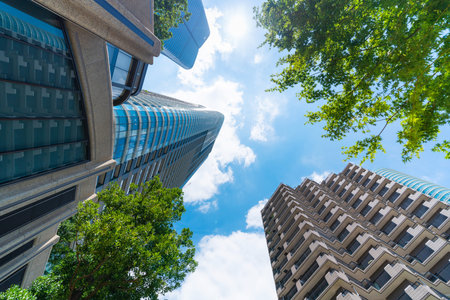 Asia Business concept for real estate, corporate construction and ecology - looking up view of panoramic modern city skyline with blue sky and green tree in Azabudai Hills, tokyo, japanの写真素材