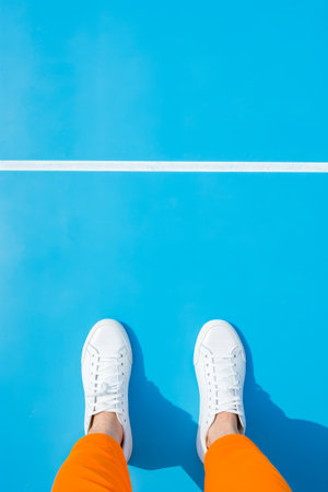 Person standing on tennis court with their feet up. Generative AI.の素材